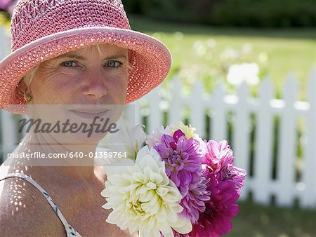 Portrait of a mature woman holding a bunch of flowers and smiling