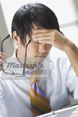 Close-up of a businessman rubbing his forehead