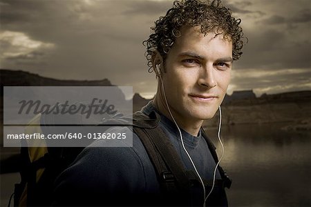 Portrait of a young man wearing headphones and carrying a backpack