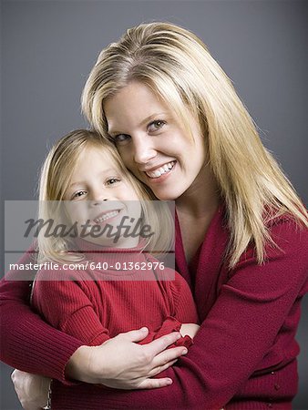 Portrait of a young woman embracing her daughter