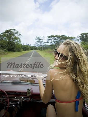 Rear view of a young woman sitting in a car