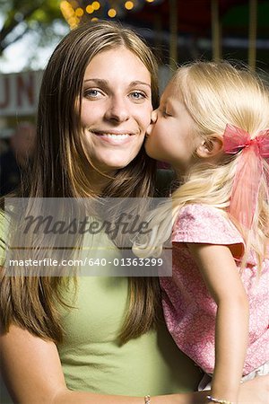Portrait of a young woman being kissed by her daughter