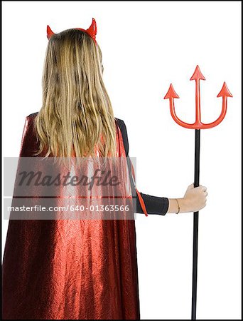 Rear view of a teenage girl wearing a devil costume holding a pitchfork