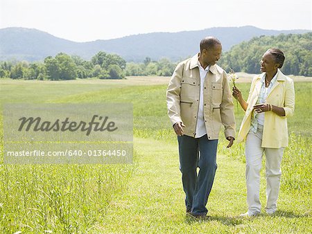 Senior man and a senior woman walking in a field