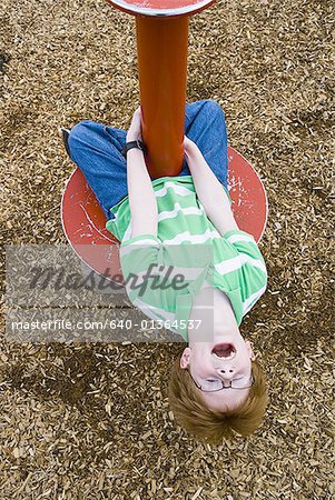 Boy playing on roundabout outdoors