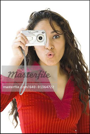 Woman in red shirt taking picture with digital camera