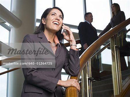 Businesswoman near stairs talking on cell phone