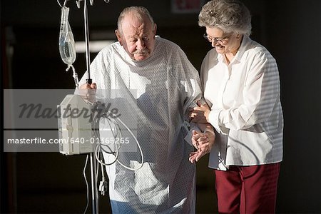 Senior woman helping a senior man walk