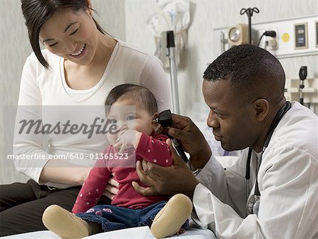 Profile of a male doctor examining a baby