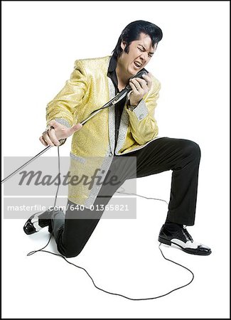 An Elvis impersonator singing into a microphone