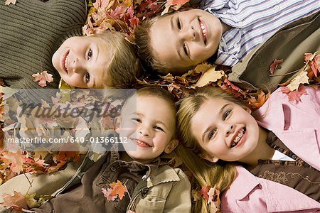 Young kids playing in a pile of fallen leaves