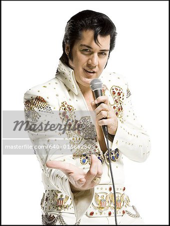 Portrait of an Elvis impersonator singing into a microphone