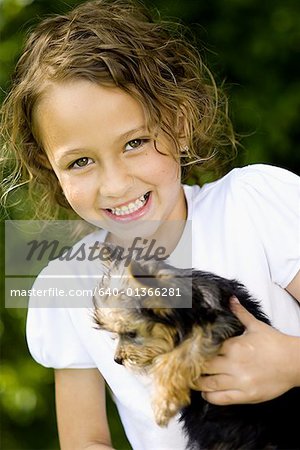 Portrait of a girl holding a puppy