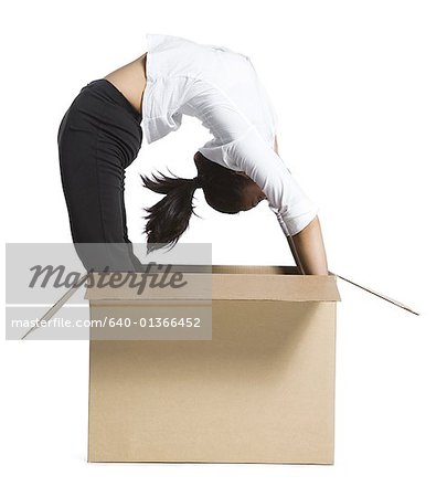 Female contortionist businesswoman inside cardboard box