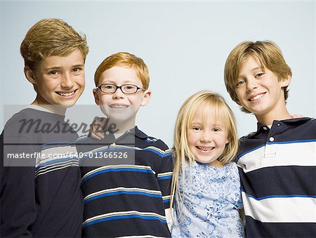 Portrait of three boys and girl smiling