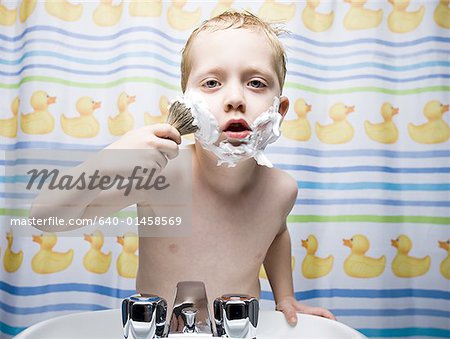 Boy shaving in bathroom