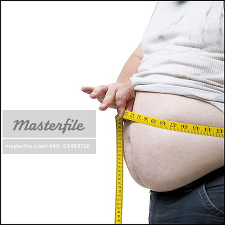 Overweight man measuring waist with measure tape, close up image. Weight  loss, motivation, fat burning Stock Photo