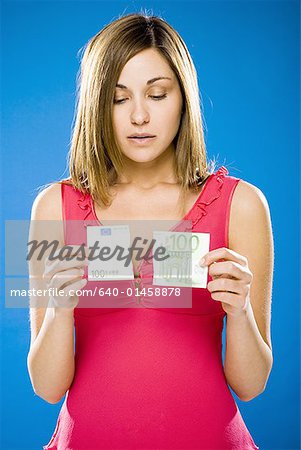 Woman with torn one hundred euro banknote