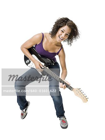 Girl with braces playing electric guitar smiling
