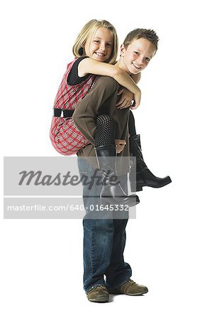 Young girl carrying sister giving piggyback ride Stock Photo