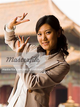 Businesswoman doing tai chi outdoors smiling