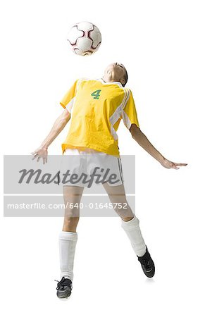 Teenage girl heading soccer ball