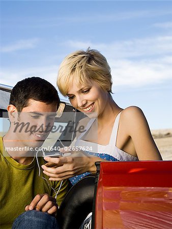 man and woman next to a red convertible