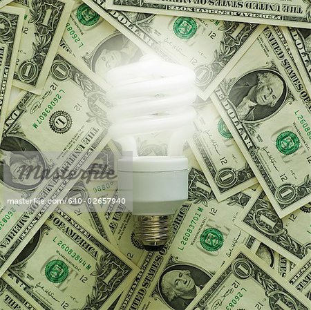 light bulb on a pile of dollar bills