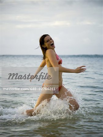 Portrait of a teenage girl running water in the sea