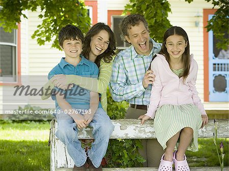 Portrait of a man and a woman smiling with their children