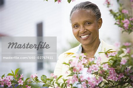 Portrait of a mature woman smiling behind flowers