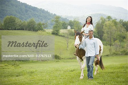 woman riding a horse with a man beside her