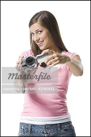 Portrait of a young woman holding a home video camera