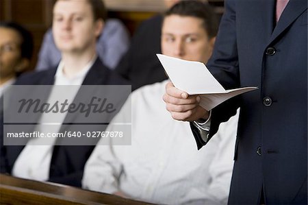 Juror standing in a jury box and reading the verdict