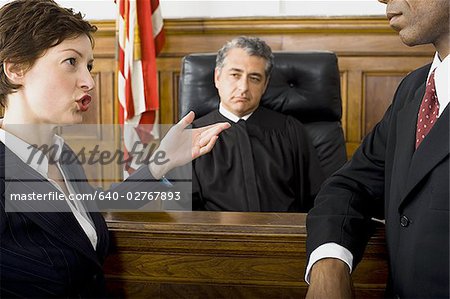 Two lawyers standing face to face in front of a male judge ...