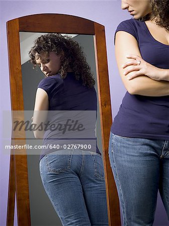 Young woman looking at her buttocks in the mirror
