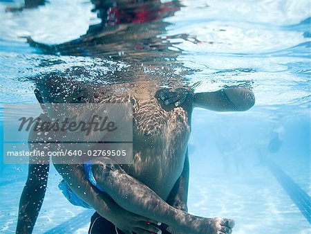 Boys swimming underwater in pool