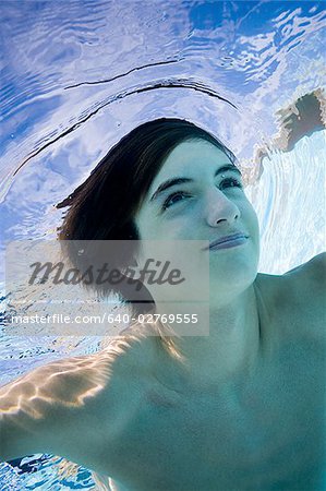 Boy swimming underwater in pool