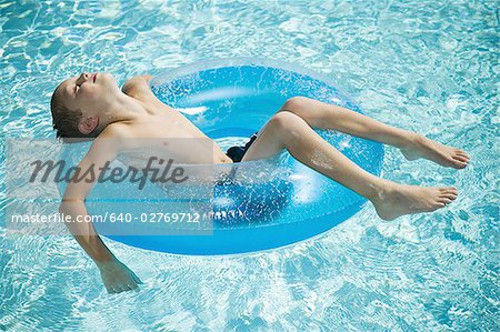 Boys on Float Tubes in Swimming Pool Stock Image - Image of