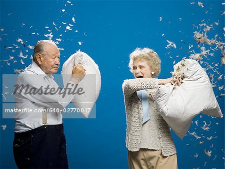 Older couple pillow fighting