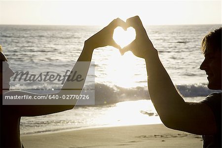 Youve Taught Me The True Meaning Of Love. A Couple Forming A Heart Shape  With Their Hands While Sitting On The Beach. Stock Photo, Picture and  Royalty Free Image. Image 198911221.