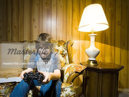 Boy with video game controller on sofa