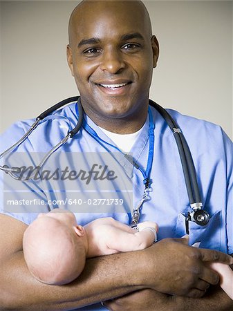 Male nurse or doctor holding newborn baby