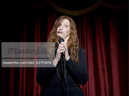 Man in suit with microphone making funny faces