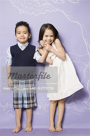 Young girl and boy holding hands smiling