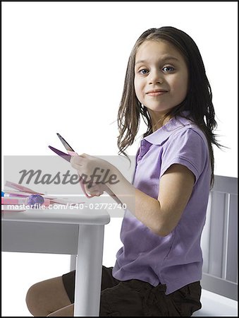 Girl sitting at table doing crafts