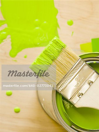 Detailed view of green paint with brush on can and paint chips