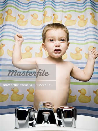 Boy flexing muscles in bathroom