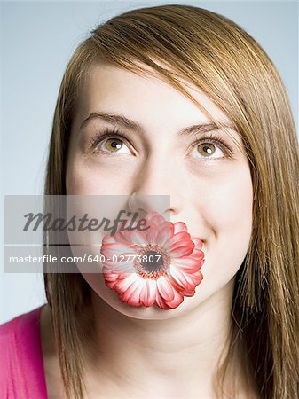 Close-up of woman with flower in her mouth
