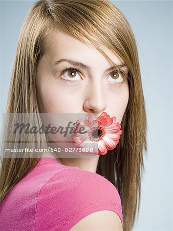 Close-up of woman with flower in her mouth